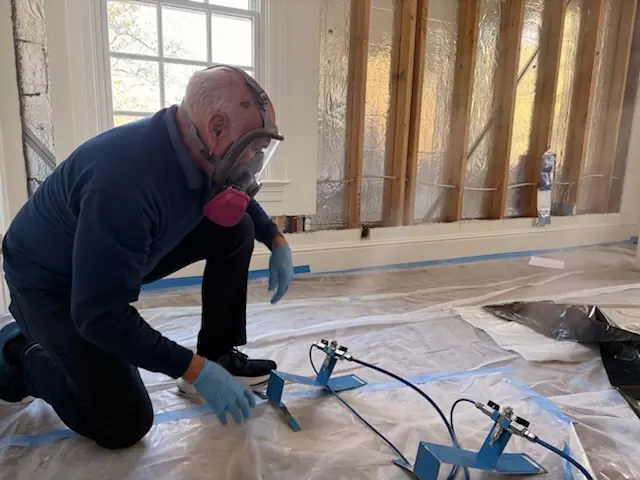 A restoration technician setting drying equipment in an Little Rock home stripped to the studs